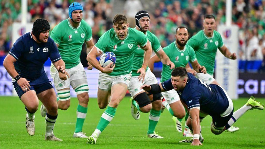 Ireland in green carrying the ball in a rugby match